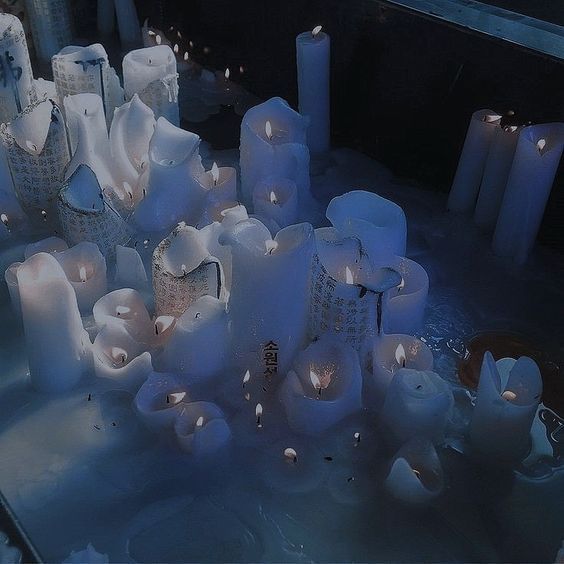 many lit candles are in the snow near each other