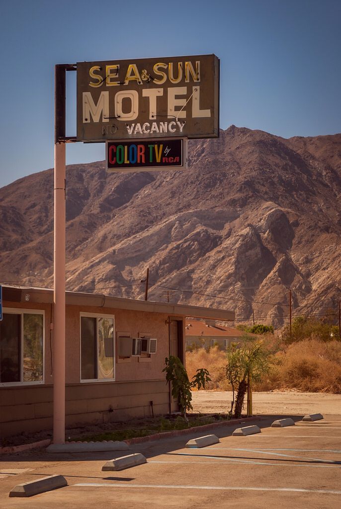 a motel sign in front of a mountain