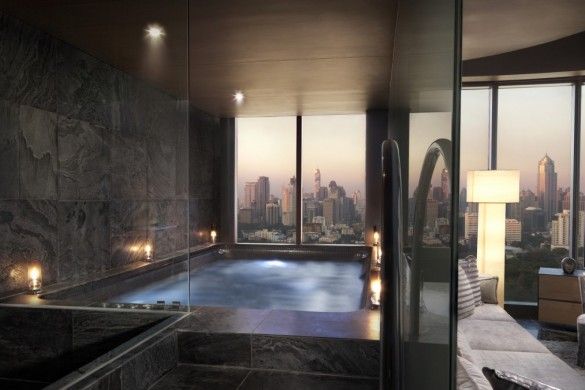 a bathroom with a large jacuzzi tub next to a window overlooking the city