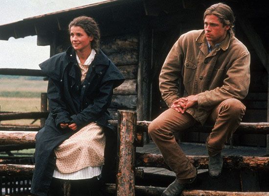 a man and woman sitting on the back of a horse