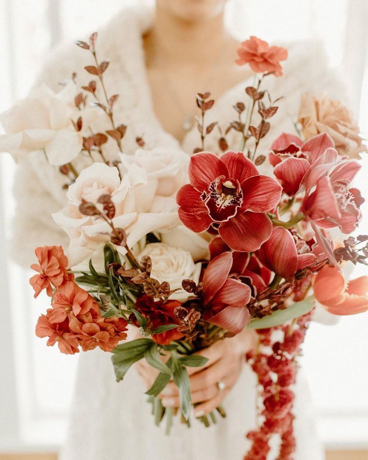 a woman holding a bouquet of flowers in her hands