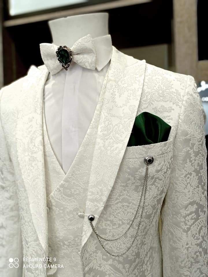 a white tuxedo with green lapel and bow tie