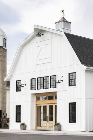 a large white barn sitting next to a tall silo