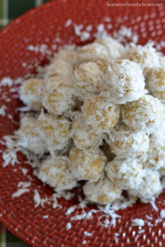 a red plate topped with coconut balls covered in powdered sugar