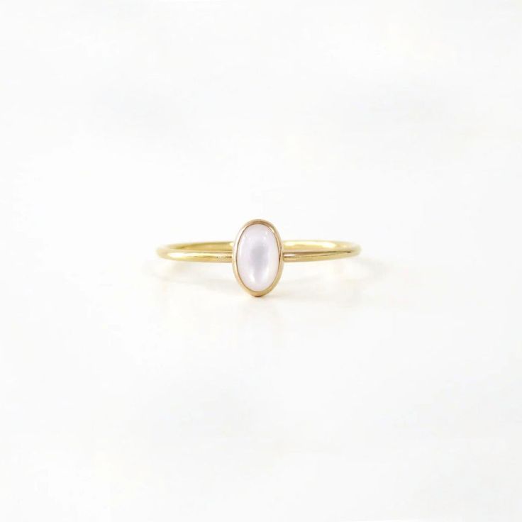 A small, delicate Gold Small Oval Pearl Ring is a delightful, feminine choice. Crafted from eco-friendly recycled gold and a sustainable gemstone, it is the perfect accessory to pair with any Sara Patino Jewelry look. The soft and luminous white pearl offers a timeless beauty that is both classic and modern. Recycled 14k gold filled Mother of Pearl is 6mm x 4mm Oval Pearl Ring, Elegant Oval Stackable Rings For Everyday, Elegant Stackable Rings For Everyday, Elegant Everyday Stackable Oval Rings, Minimalist Oval Cabochon Wedding Jewelry, Minimalist Oval Cabochon Wedding Ring, Dainty Oval Birthstone Ring, Delicate White Moonstone Ring In 14k Gold, Minimalist Oval Cabochon Opal Ring