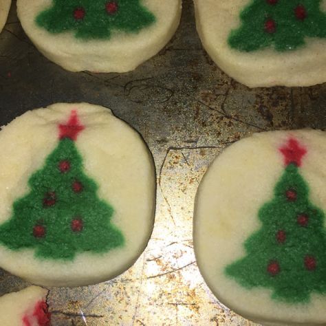 christmas tree decorated cookies sitting on top of a cookie sheet