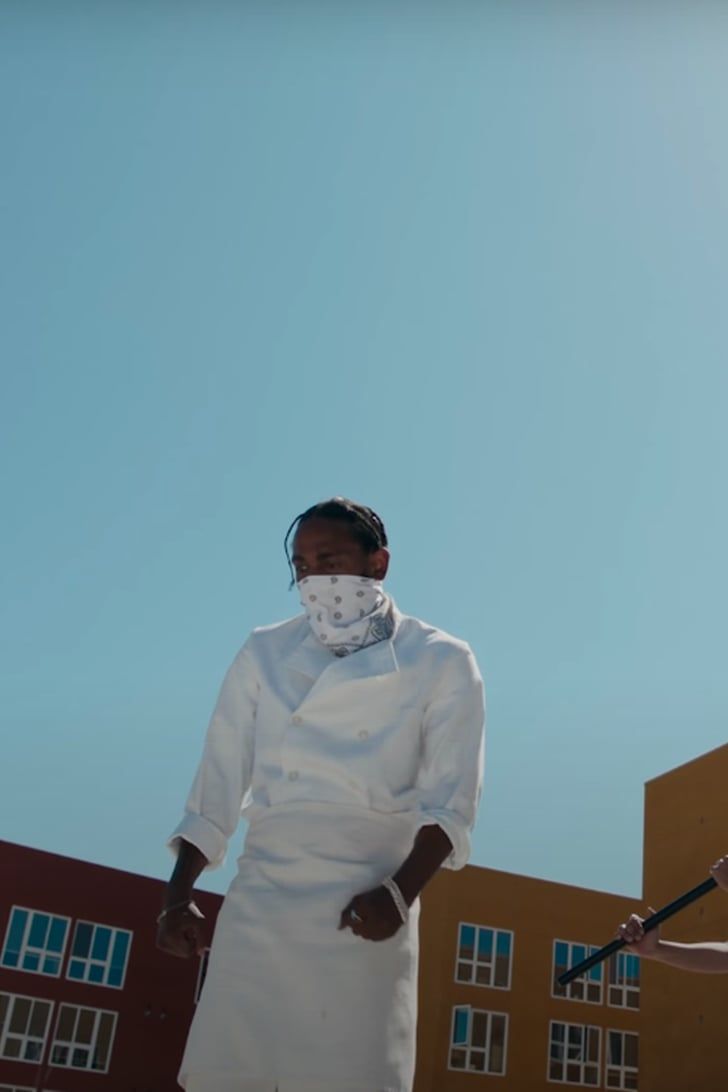 two people standing in front of a building wearing white clothing and bandannas on their heads