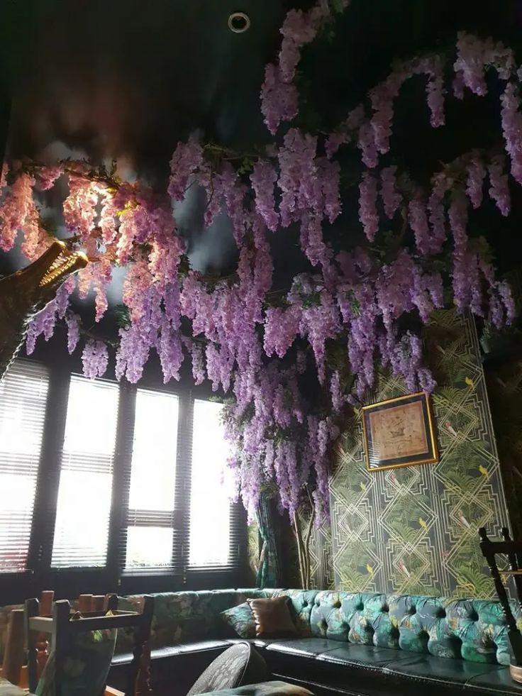 purple wisters hang from the ceiling in a restaurant