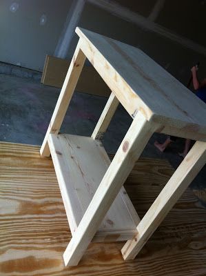 a small wooden table sitting on top of a hard wood floor next to a person