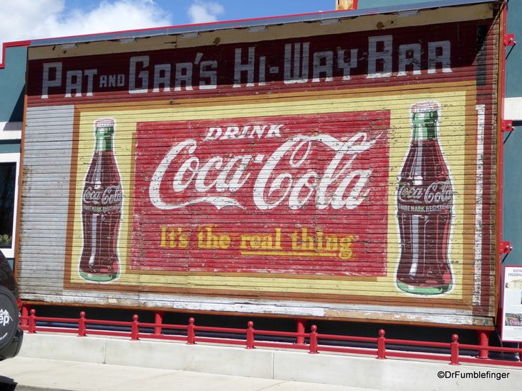 an old coca - cola advertisement painted on the side of a building