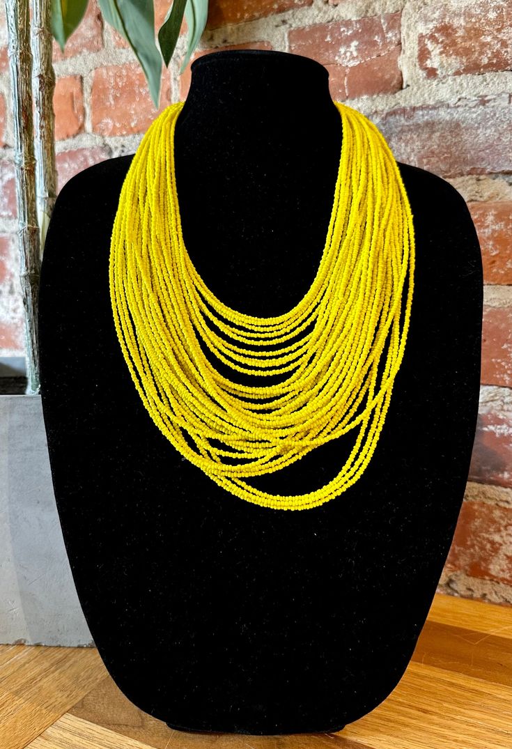 Yellow Multi-Layered Beaded Strand Bib Necklace Set in Brushed Brass & Gold Tone Metals Yellow Acrylic Beads 14K Gold Plated Lobster Clasp Closure Approximate Measurements: Length- 12" + 3" Extender Glowing like the sunshine, this is a statement necklace that will have all eyes on you! Elegant Yellow Beaded Necklaces With Tiny Beads, Elegant Yellow Jewelry With Tiny Beads, Yellow Multi-strand Polished Beaded Necklaces, Yellow Multi-strand Polished Beads Jewelry, Yellow Multi-strand Jewelry With Polished Beads, Yellow Beaded Multi-strand Necklaces, Traditional Yellow Beaded Necklaces With Tiny Beads, Traditional Yellow Beaded Necklace With Tiny Beads, Traditional Yellow Necklaces With Faceted Beads