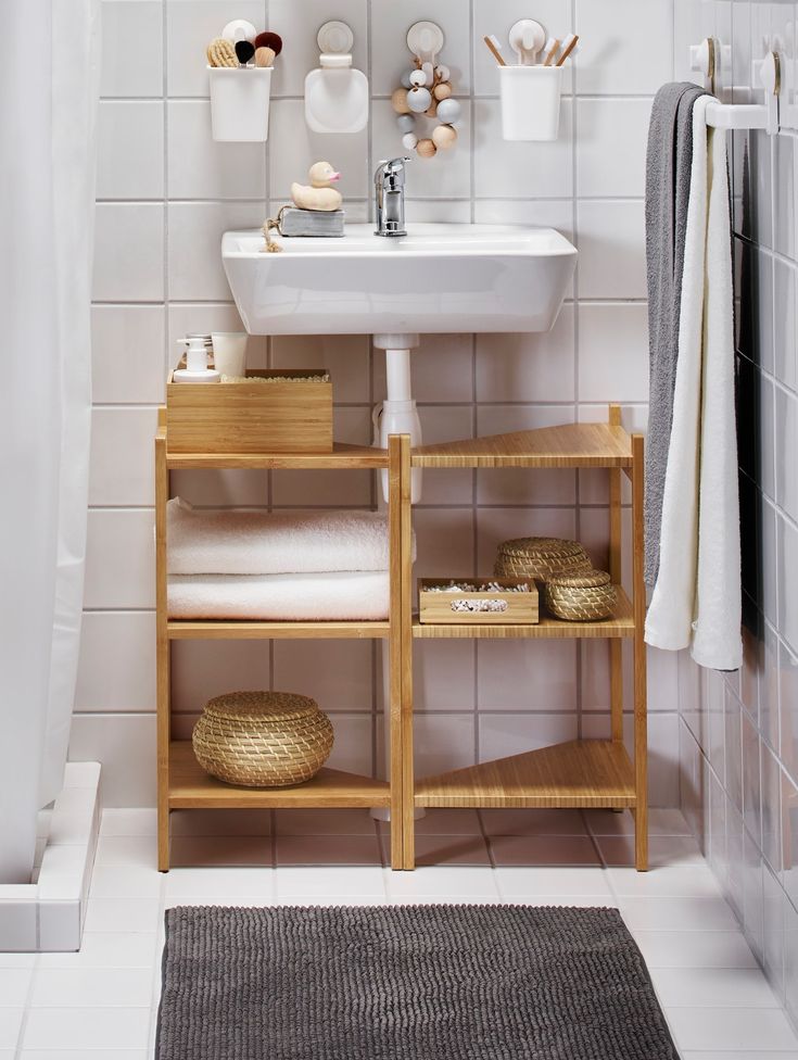 a bathroom with white tile and wooden shelves