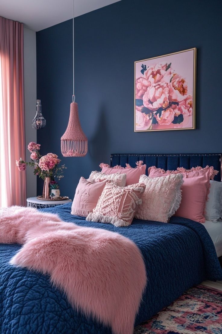 a bedroom with blue walls and pink bedding, rugs and pillows on the floor