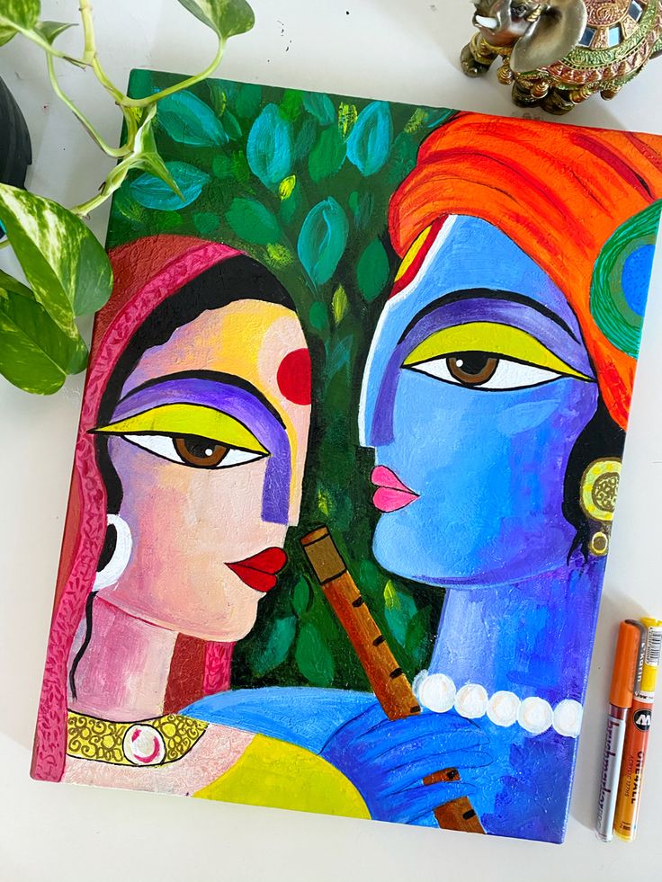 a painting with two women on it next to a potted plant and crayons