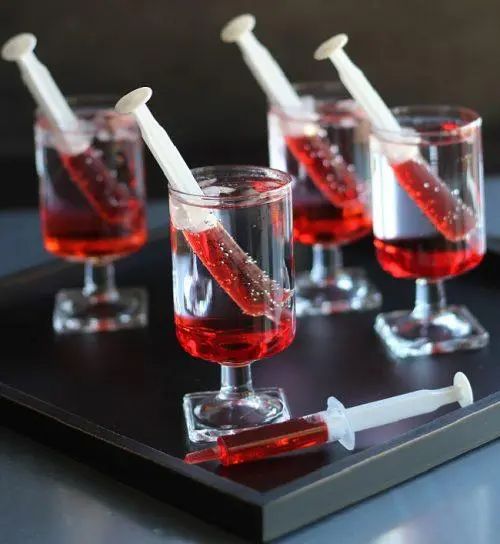 three glasses filled with red liquid sitting on top of a black tray next to a toothbrush