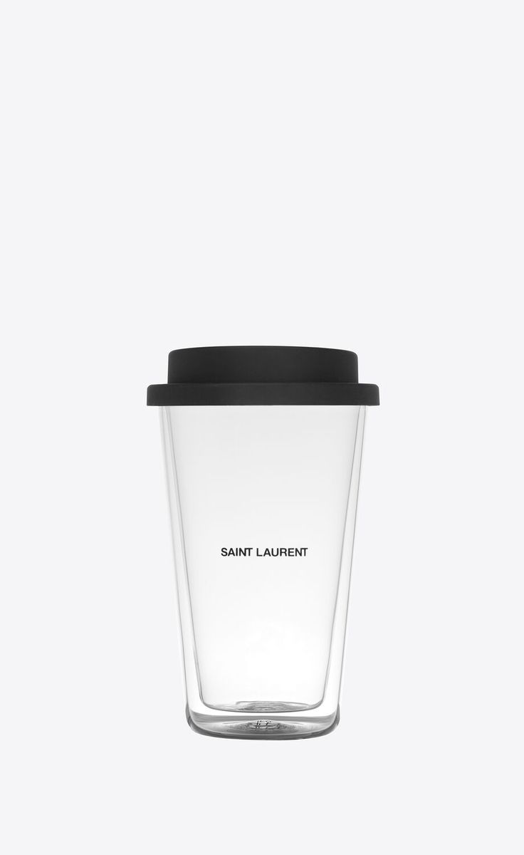 a glass cup with a black lid and the words saint laurent on it is shown