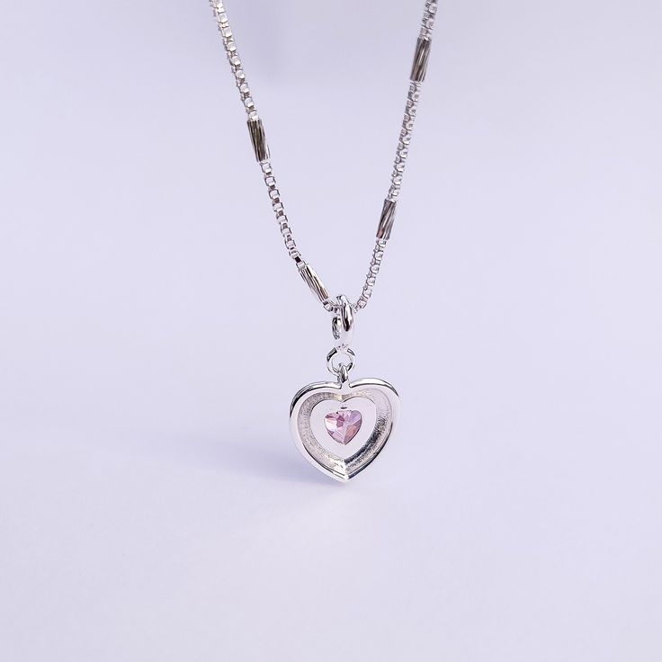 Introducing our Pink Glam Heart Necklace - crafted in Sterling Silver with a heart-shaped pink crystal at its core. This unique chain necklace features a sparkling pink crystal heart pendant, on a Sterling Silver heart shape base adding sophistication to any look. Wear it long or short with the adjustable clasp. Elevate your style with this enchanting piece that radiates love and glamour. Main Stone: heart shaped lab diamond Stone Color: pink Metal Material: 925 Sterling Silver Chain Lenght: 16 Pink Glam, Crystal Heart Pendant, Necklace Craft, 925 Sterling Silver Chain, Stone Heart, Crystal Heart, Sterling Silver Heart, Pink Crystal, Metal Material