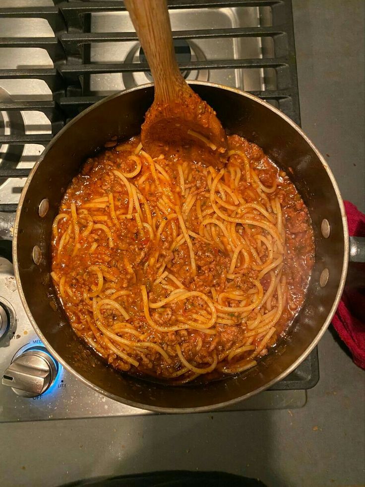 spaghetti being cooked in a pan on the stove