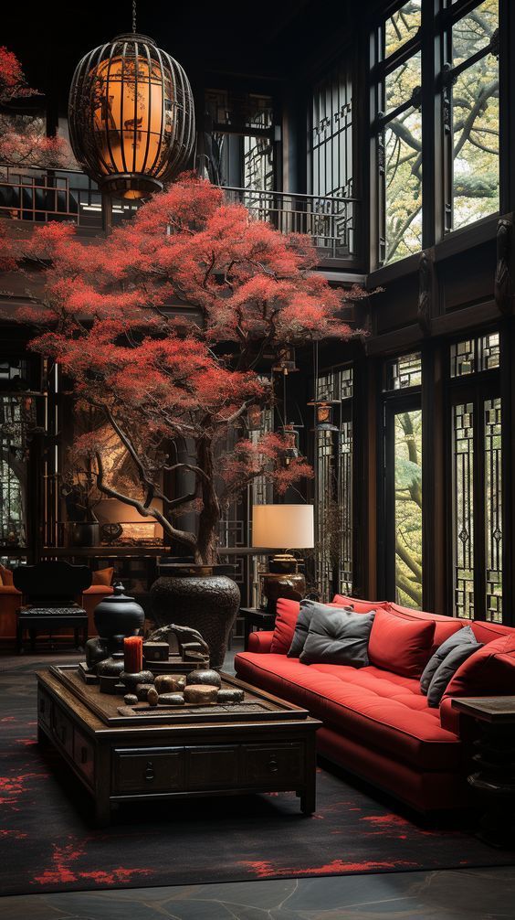 a living room filled with red couches next to a tall tree in front of large windows