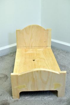 a wooden bed frame sitting on top of carpeted floor next to a white wall