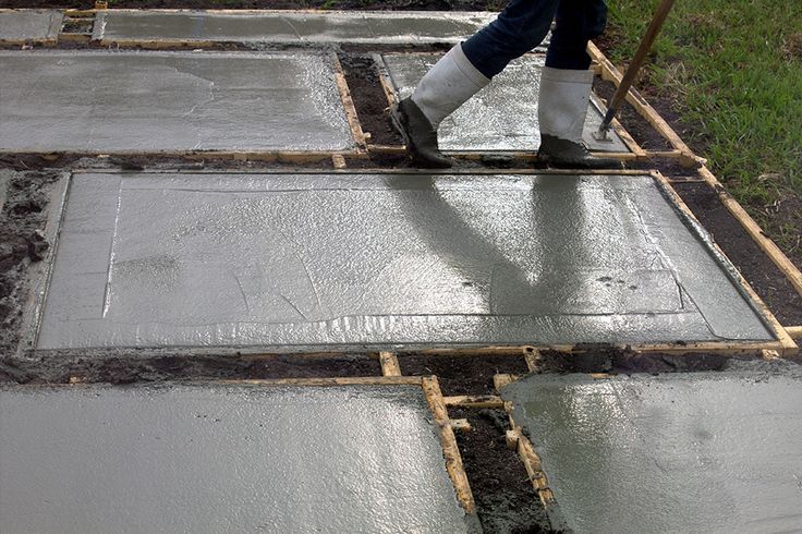 a person in boots and rubber boots is working on concrete