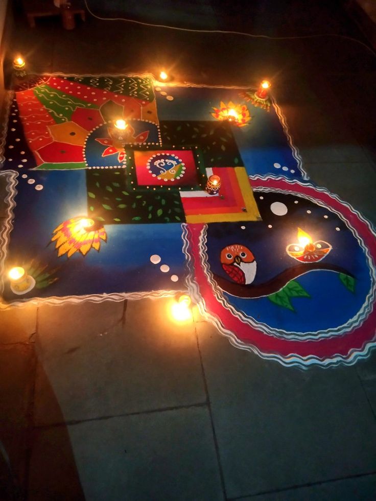 candles are lit on the ground in front of a decorated mat