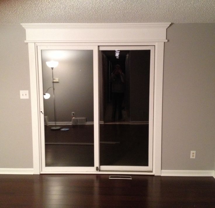 an empty room with sliding glass doors and hard wood flooring