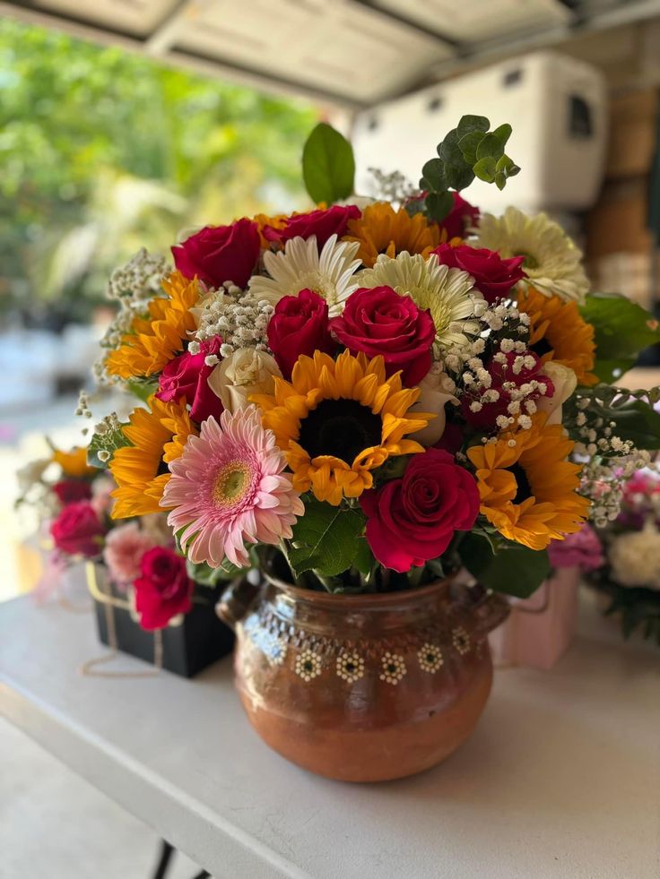 a vase filled with lots of different colored flowers