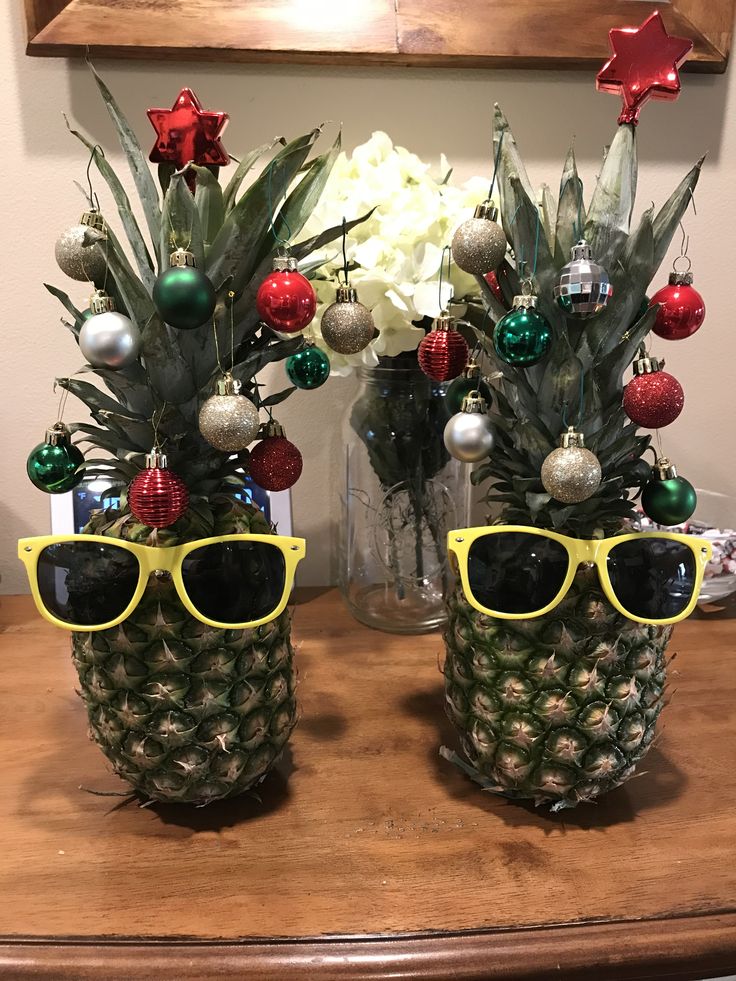 two pineapples wearing sunglasses with christmas decorations