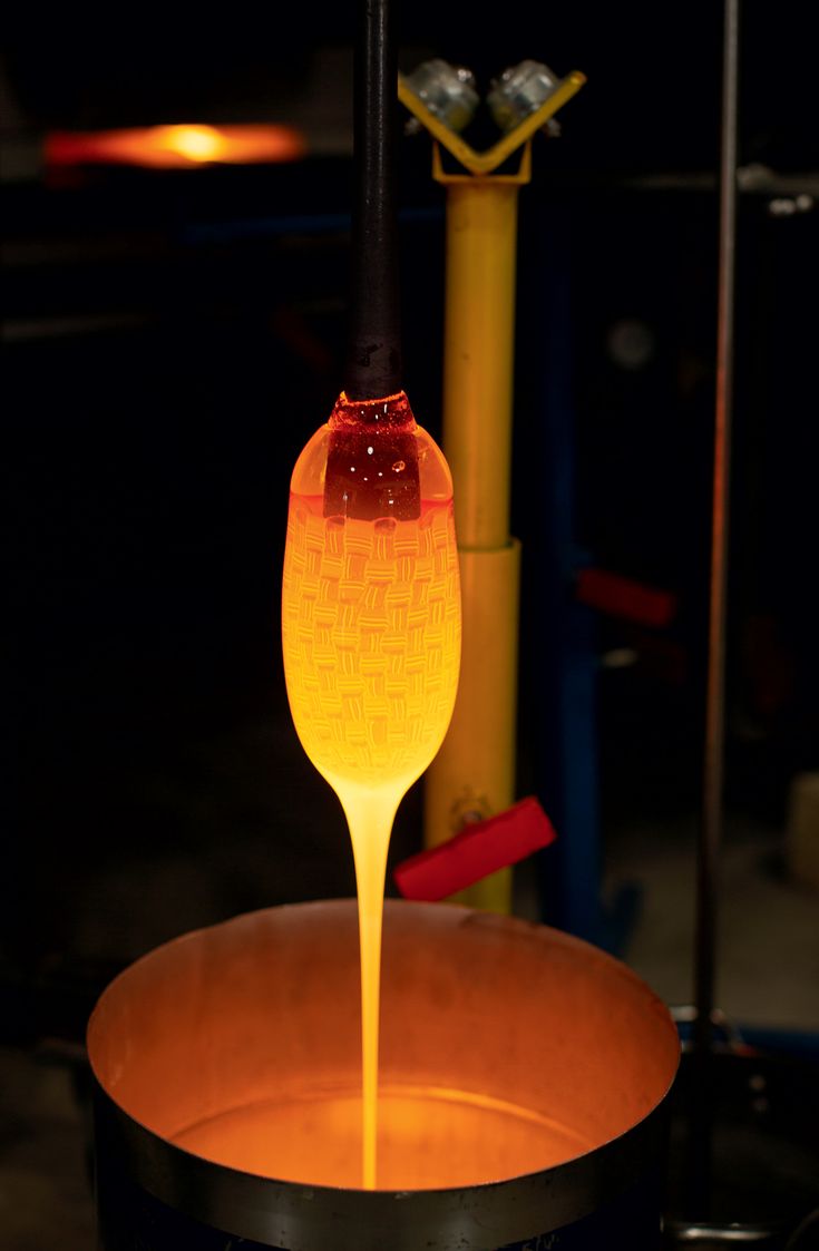 an orange liquid pouring into a black pot