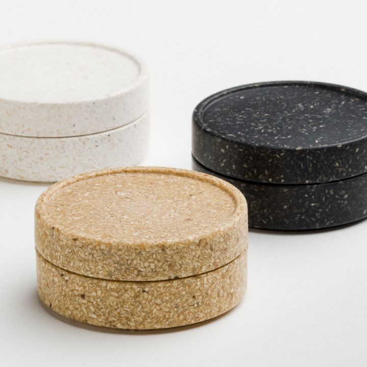 three black, white and brown coasters sitting next to each other