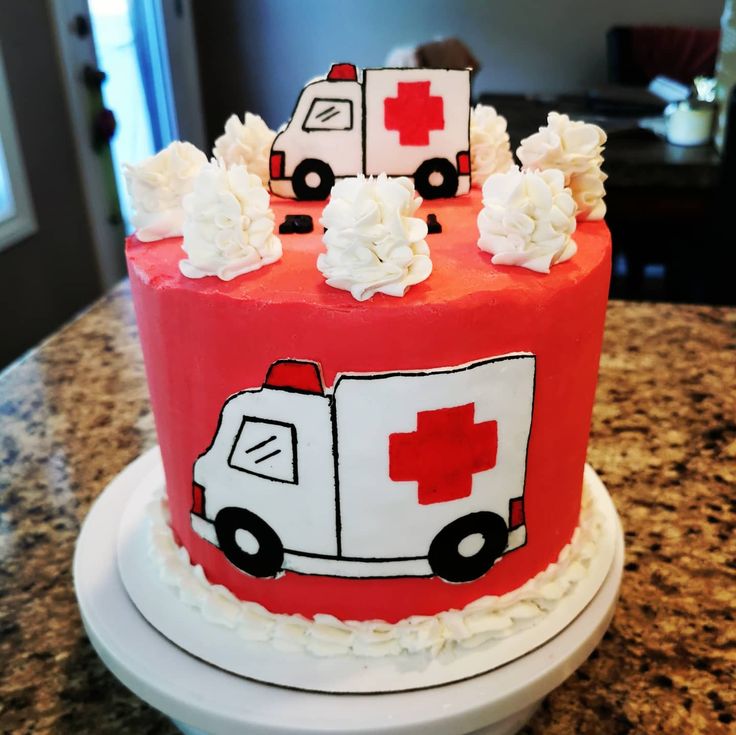 a red and white cake with an ambulance on it