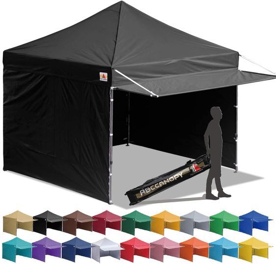 a black canopy tent with the sidewalls open and colors in front of it