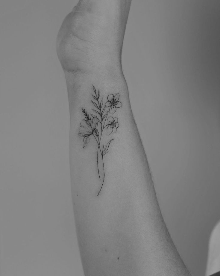 a woman's arm with a flower tattoo on it