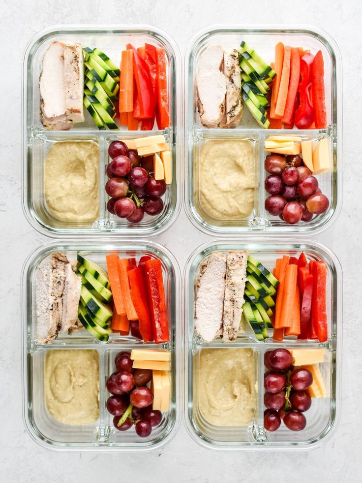 four plastic containers filled with different types of food and veggies on top of each other