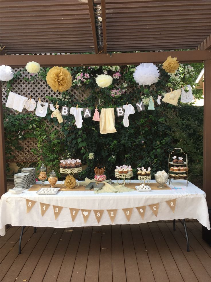 an outdoor baby shower with cake and cupcakes