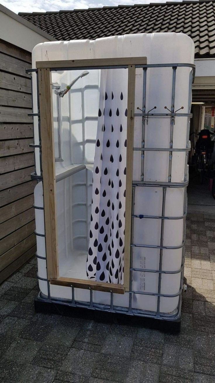 a white and black shower curtain sitting on top of a plastic container next to a building