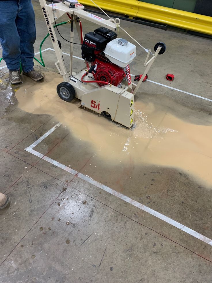 a man is using a machine to clean the parking lot