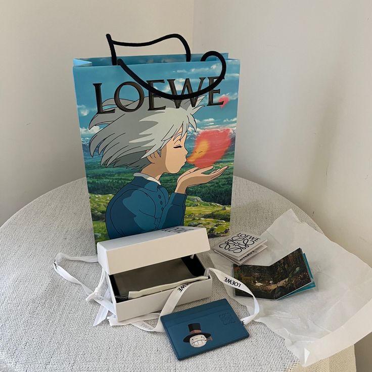 a bag with an anime character on it sitting on a table next to some other items