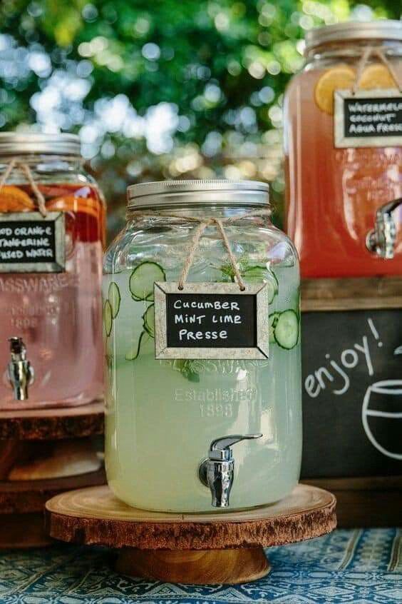 three jars filled with liquid sitting on top of a wooden stand next to each other