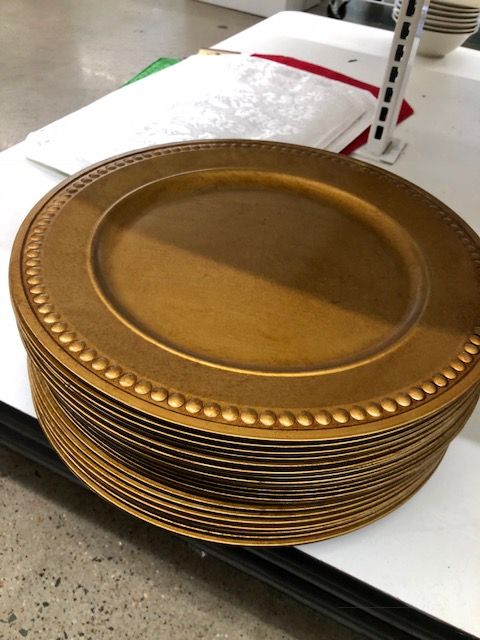 a stack of gold plates sitting on top of a counter