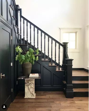 a plant in a pot sitting on top of a table next to a stair case