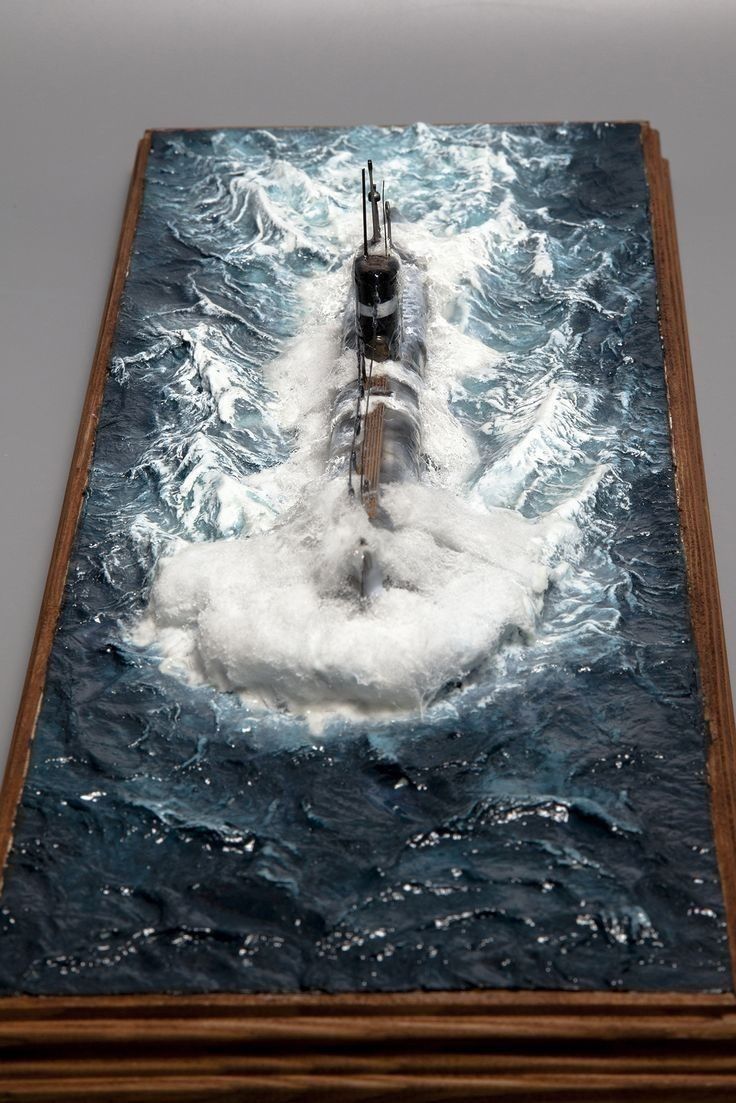 a submarine floating in the ocean surrounded by foamy water and wooden planks,