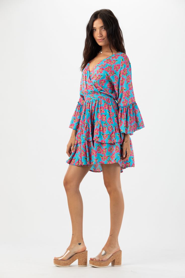 Elevate your wardrobe with our Felix MIni Dress. This charming long sleeve mini dress embraces the whimsical beauty of feminine style. With its flattering silhouette and playful ruffle detailing, this dress is guaranteed to make you feel effortlessly elegant and confident with every wear. Details: 100% Rayon Hand wash in cold water and Lay flat to dry Features: Unlined, V-neck overlap bodice, Tiered flowing sleeves with ruffle detail, Elastic waistband for adjustable fit, Self tie adjustable wai Flowy Long Sleeve Tiered Dress With Ruffles, Flowy Long Sleeve Ruffle Dress With Ruffle Hem, Flowy Long Sleeve Tiered Dress, Blue Mini Long Sleeve Dress For Spring, Summer Long Sleeve Tiered Dress With Ruffle Hem, Blue Mini Length Long Sleeve Dress For Spring, Long Sleeve Tiered Dress With Ruffle Hem For Summer, Long Sleeve Dress With Ruffle Hem For Brunch, Long Sleeve Mini Dress With Ruffle Hem For Brunch