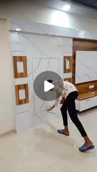 a woman is bending over in the middle of a room with white walls and wooden furniture