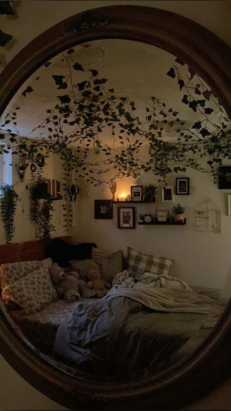 a mirror reflecting a bed with pillows and plants on the wall in front of it