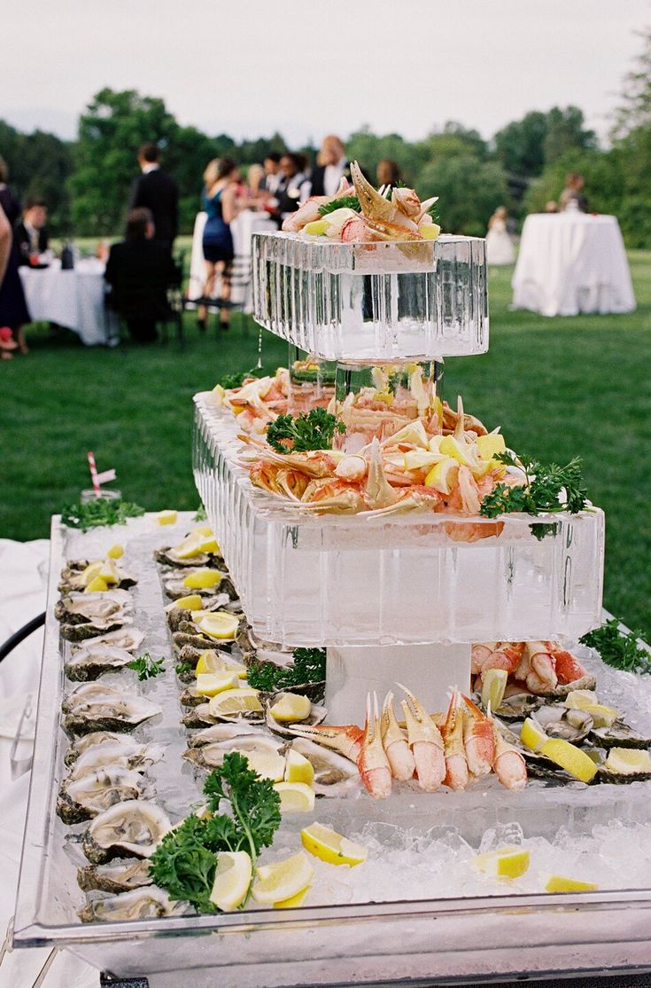 a large platter filled with lots of food sitting on top of a table covered in ice