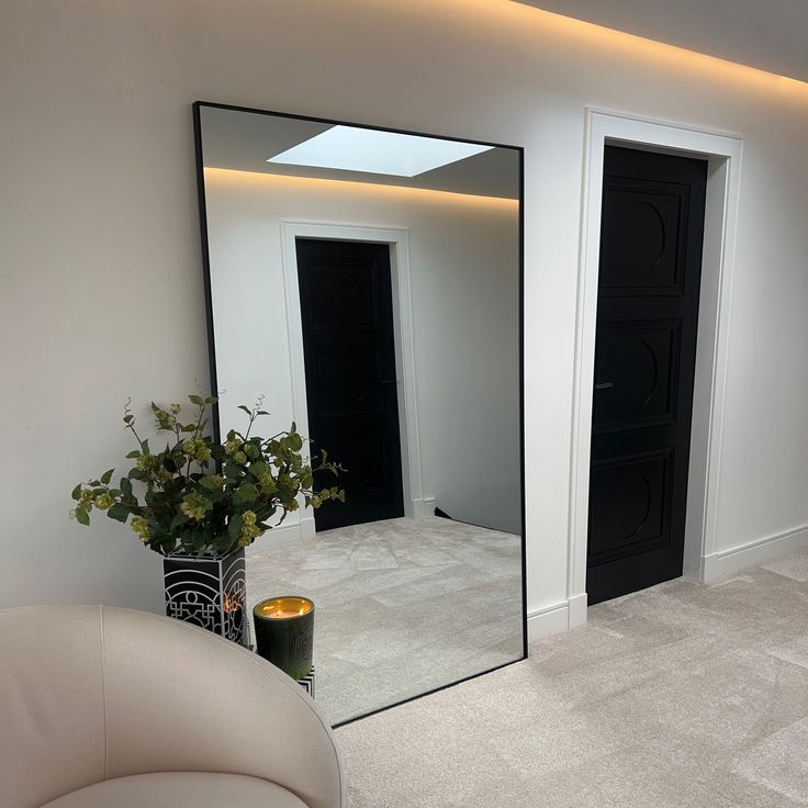 a large mirror sitting on the side of a wall next to a white couch