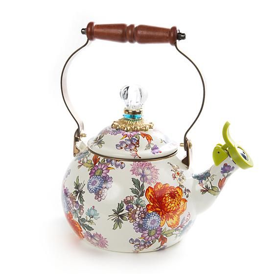 a tea pot with a wooden handle decorated with flowers