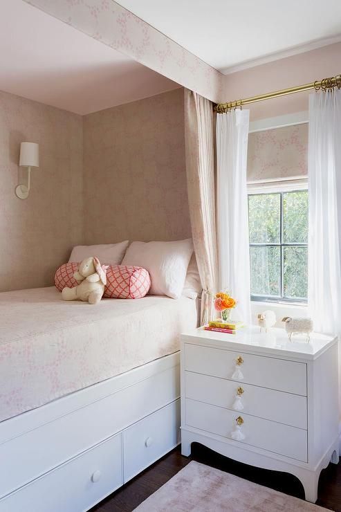 a white bed sitting next to a window in a bedroom